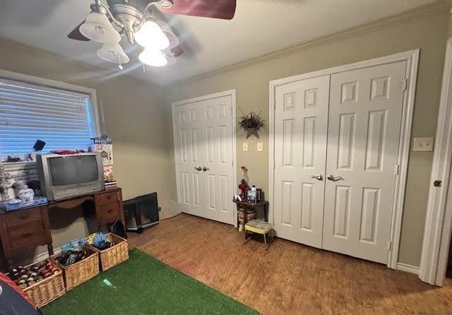 interior space with hardwood / wood-style flooring, ornamental molding, and ceiling fan