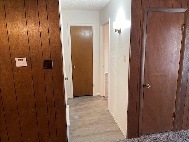 hall with baseboards and light wood-type flooring