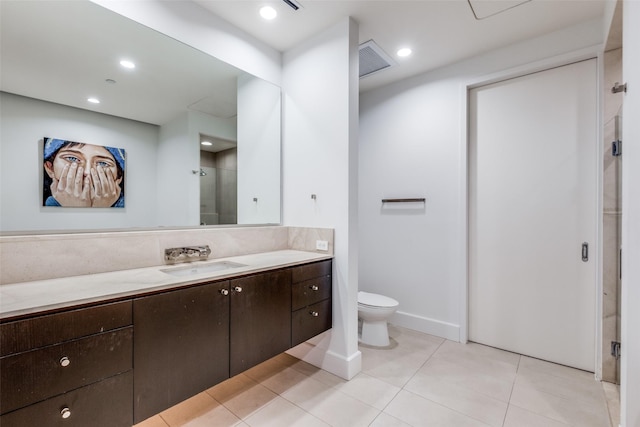 bathroom featuring tile patterned flooring, vanity, toilet, and a shower with door