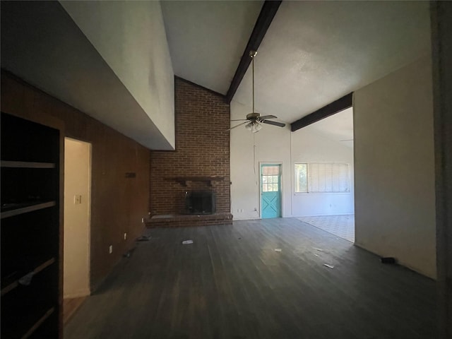 unfurnished living room featuring dark hardwood / wood-style floors, high vaulted ceiling, a fireplace, beamed ceiling, and ceiling fan