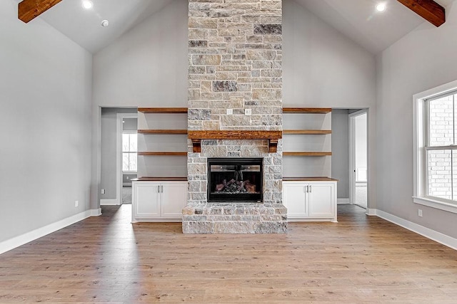 unfurnished living room with plenty of natural light, high vaulted ceiling, and light hardwood / wood-style flooring