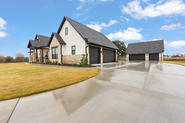 view of front of house featuring a garage, an outbuilding, and a front yard