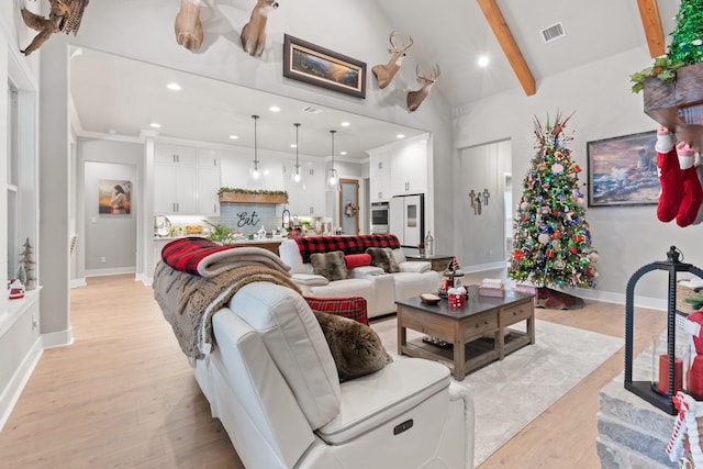 living room with lofted ceiling with beams and light hardwood / wood-style floors