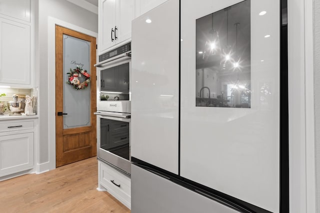 kitchen featuring white cabinets, white fridge, light hardwood / wood-style floors, and double oven