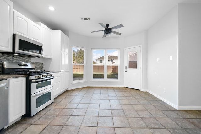 kitchen featuring appliances with stainless steel finishes, backsplash, ceiling fan, white cabinetry, and light tile patterned flooring