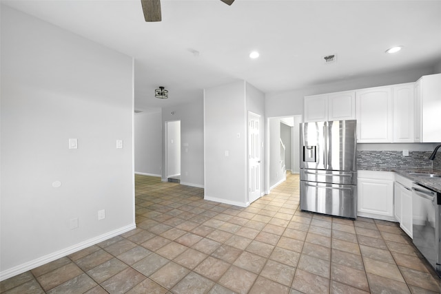 kitchen with backsplash, sink, appliances with stainless steel finishes, light stone counters, and white cabinetry