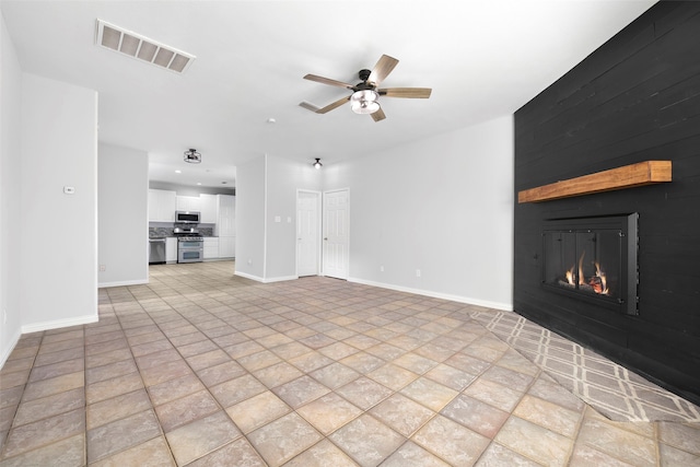 unfurnished living room featuring ceiling fan and a fireplace