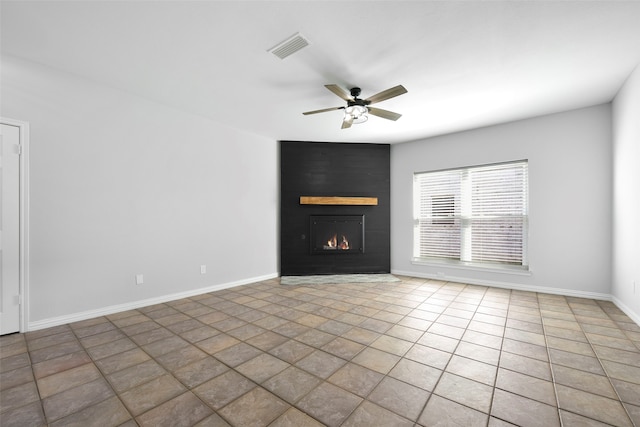 unfurnished living room featuring tile patterned floors, ceiling fan, and a large fireplace