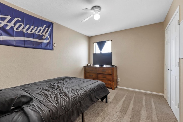 bedroom featuring ceiling fan, light carpet, and a closet