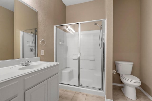 bathroom with tile patterned flooring, vanity, toilet, and a shower with door