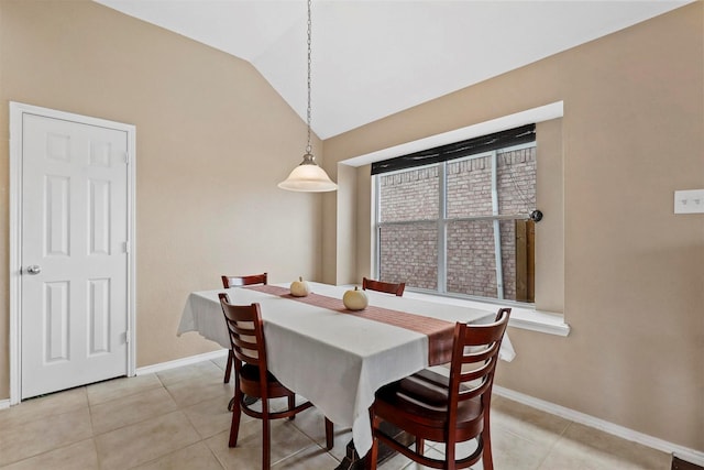 dining area featuring vaulted ceiling and light tile patterned flooring