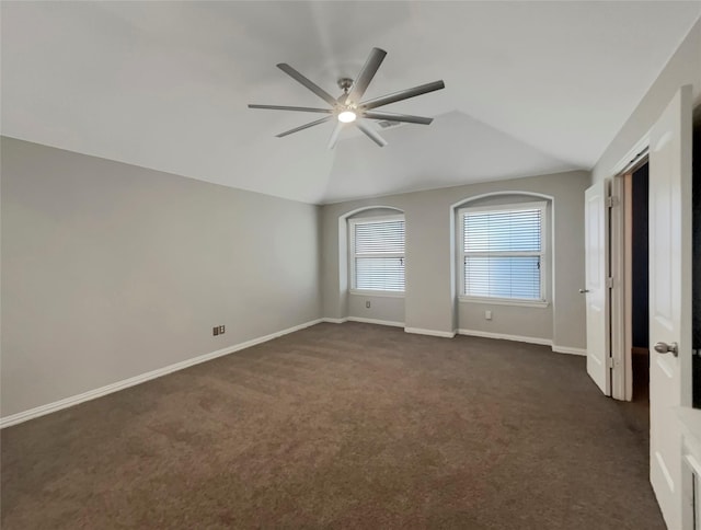 spare room featuring ceiling fan, lofted ceiling, and dark colored carpet