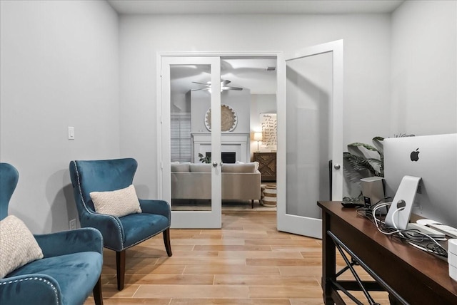 sitting room with ceiling fan, french doors, and light hardwood / wood-style floors