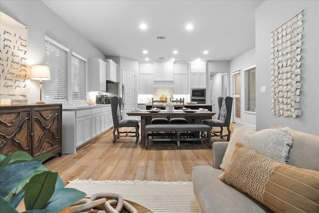 interior space with light hardwood / wood-style floors, white cabinetry, and stainless steel appliances