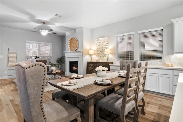 dining space featuring ceiling fan and light wood-type flooring