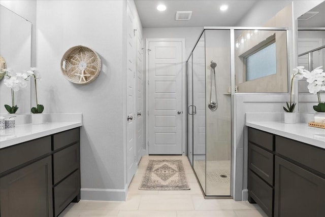 bathroom featuring tile patterned flooring, vanity, and a shower with shower door