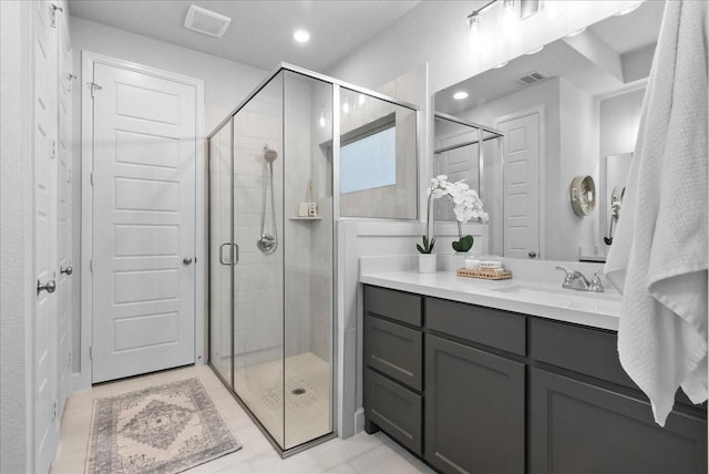 bathroom featuring vanity, tile patterned floors, and a shower with shower door