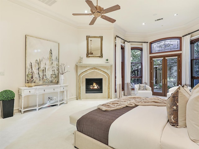 carpeted bedroom featuring french doors, crown molding, access to outside, ceiling fan, and a high end fireplace