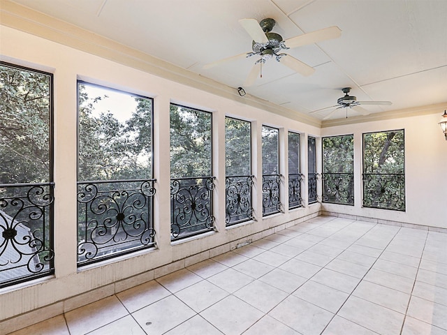 unfurnished sunroom featuring ceiling fan and a wealth of natural light