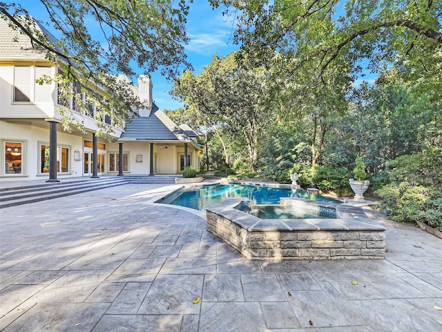 view of pool with an in ground hot tub and a patio