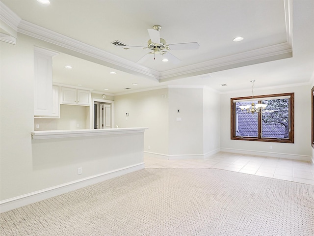 carpeted spare room featuring a tray ceiling, crown molding, and ceiling fan with notable chandelier