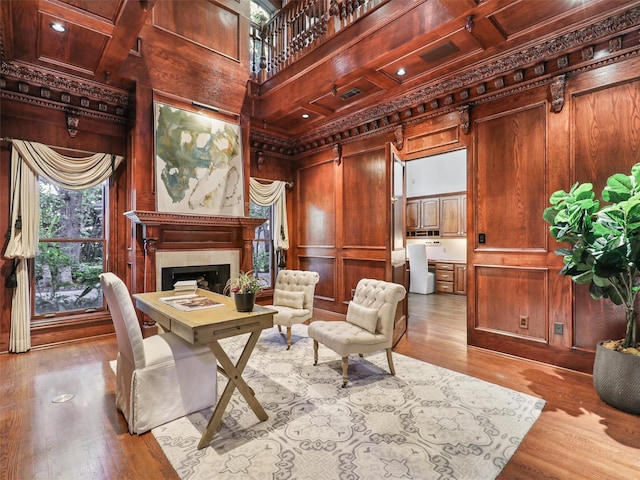 interior space featuring wooden walls, coffered ceiling, and a high ceiling