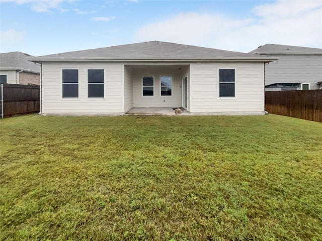 rear view of property featuring a patio and a lawn