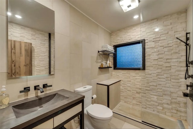 bathroom with vanity, toilet, ornamental molding, tile walls, and walk in shower