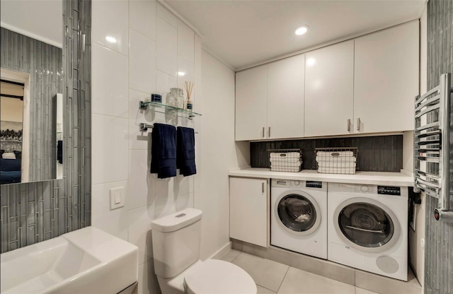 bathroom featuring washer and clothes dryer, toilet, and tile patterned floors