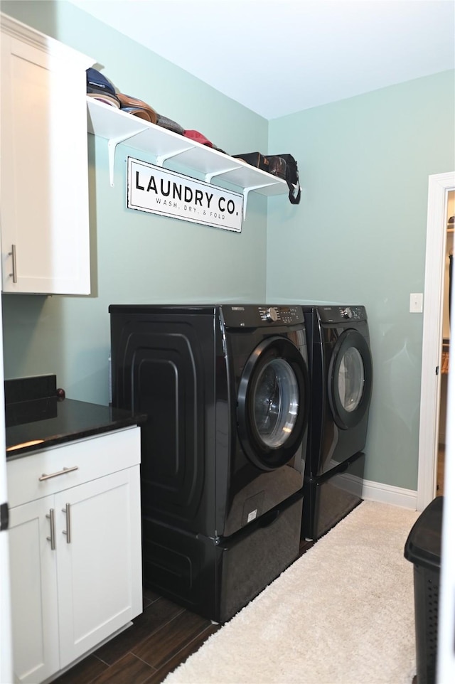 laundry room with cabinets, dark wood-type flooring, and independent washer and dryer