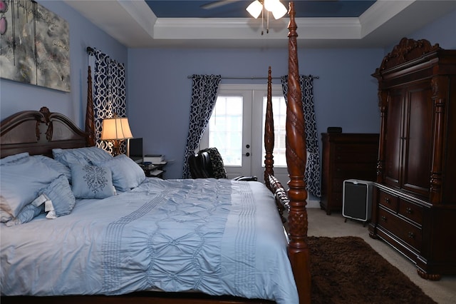 bedroom with crown molding, light colored carpet, a tray ceiling, and access to outside