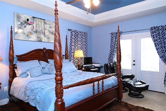 carpeted bedroom with crown molding, a raised ceiling, and french doors