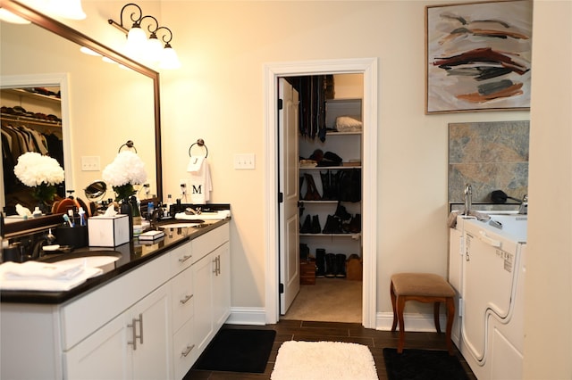 bathroom with washer / clothes dryer, vanity, and backsplash