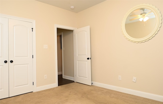 unfurnished bedroom featuring light colored carpet and a closet