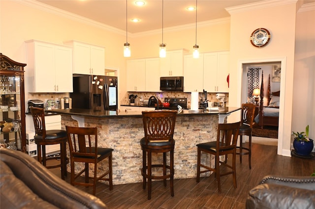 kitchen with white cabinetry, stainless steel appliances, and a kitchen breakfast bar