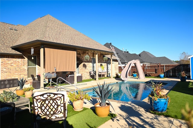 view of swimming pool with a patio and a water slide