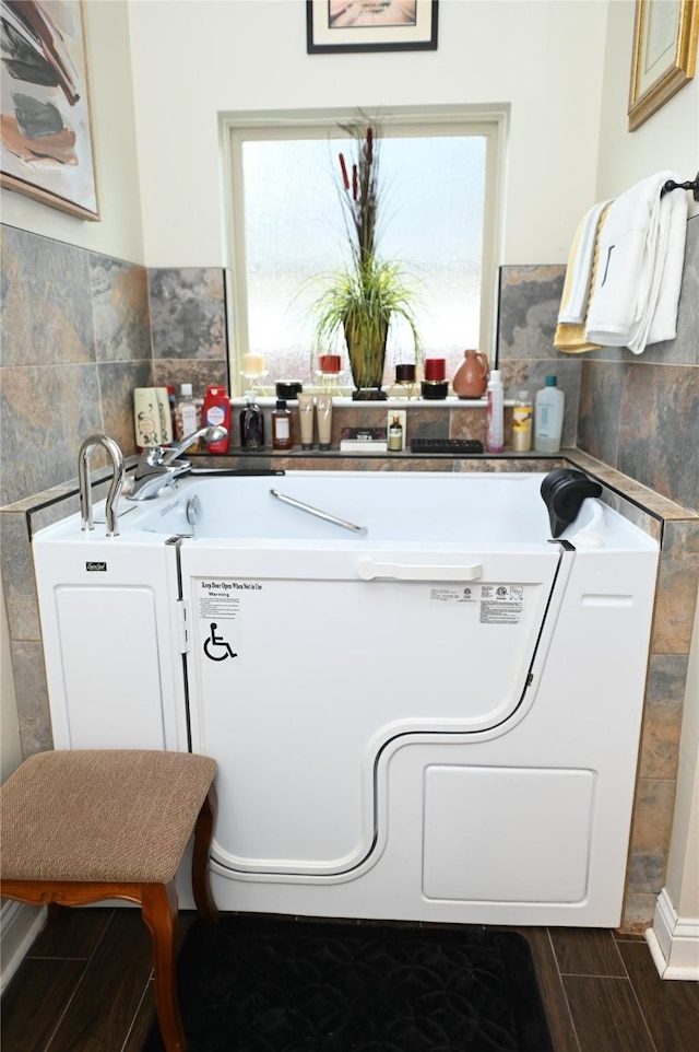 laundry area with tile walls