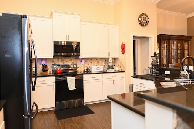 kitchen with white cabinetry, ornamental molding, appliances with stainless steel finishes, dark hardwood / wood-style floors, and backsplash