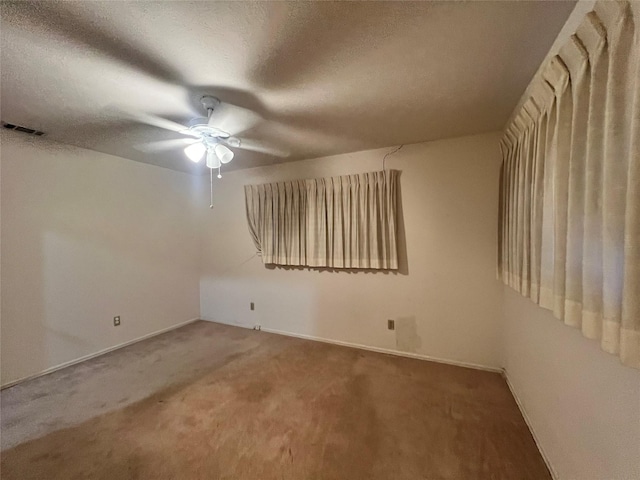 carpeted empty room with ceiling fan and a textured ceiling