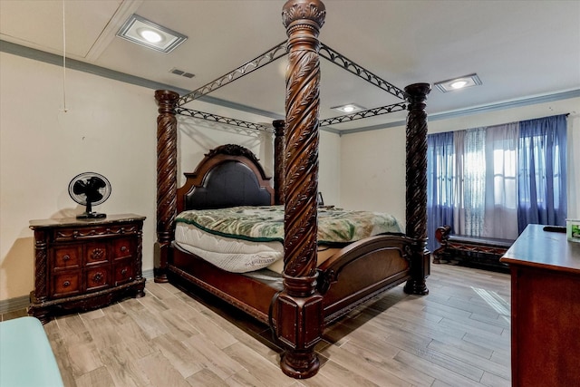 bedroom featuring crown molding and light hardwood / wood-style flooring