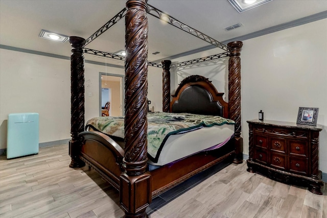 bedroom featuring crown molding and light hardwood / wood-style flooring