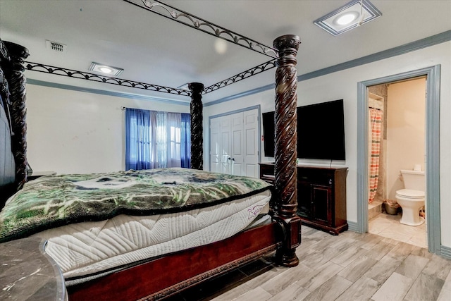 bedroom with ensuite bathroom, light hardwood / wood-style flooring, and a closet