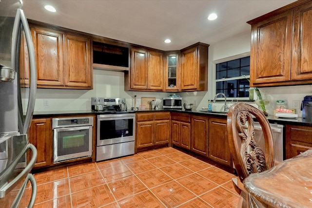 kitchen featuring sink, light tile patterned flooring, and stainless steel appliances