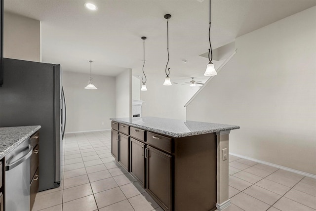 kitchen with light tile patterned floors, ceiling fan, dark brown cabinets, stainless steel appliances, and light stone counters