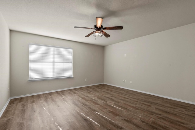 spare room with dark wood-type flooring, a textured ceiling, and ceiling fan