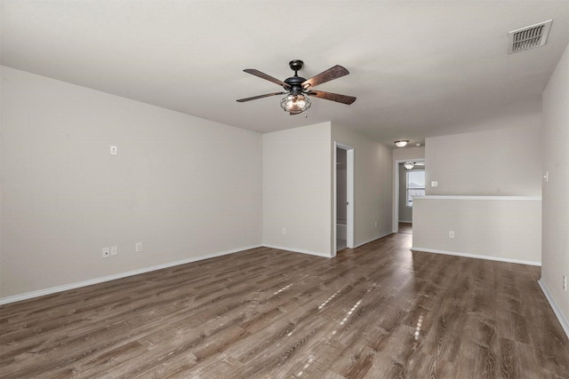 empty room with ceiling fan and dark hardwood / wood-style flooring