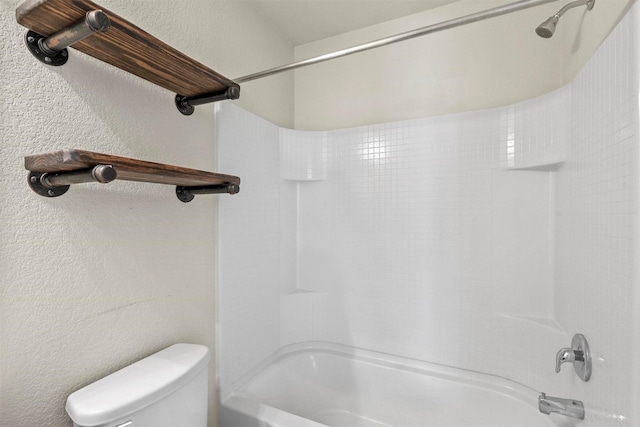 bathroom featuring shower / tub combination and toilet