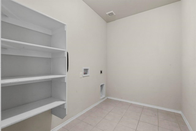 clothes washing area with light tile patterned floors, washer hookup, and hookup for an electric dryer