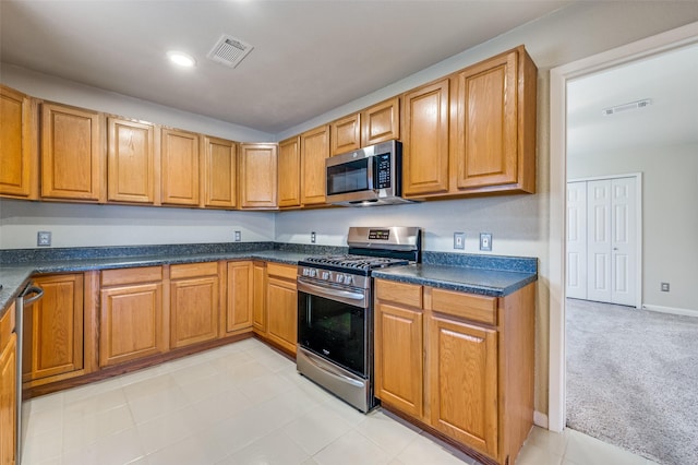 kitchen with light carpet and appliances with stainless steel finishes