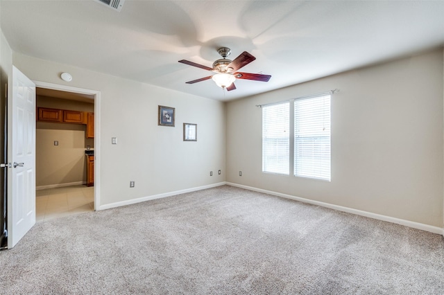 empty room with ceiling fan and light carpet